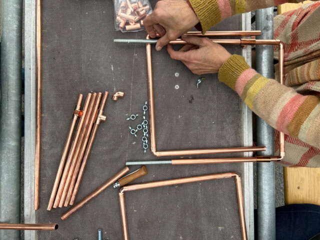 Quartier rouge - Araignées sociales zone - Constructions des métiers à tisser, faits à partir de tuyaux de plomberie en cuivre.