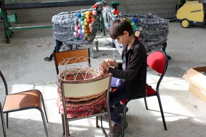 Quartier rouge - Nous soutenir - Un élève de la classe de l'école primaire de Felletin confectionne une chimère en textile dans le cadre de L'atelier bestiaire avec l'artiste Natacha Sansoz. 