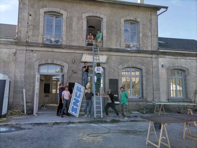 Quartier rouge - La gare en commun - Décrochage de l'enseigne SNCF de la façade de la gare. 